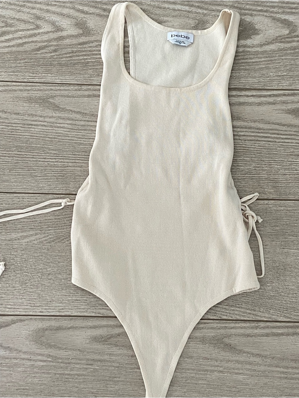 bebe Cream One-Piece bodysuit with Side Ties. Size: Small.